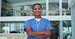 Surgeon, woman and arms crossed with face, smile and pride for career in healthcare at hospital. Doctor, nurse and person with confidence for wellness in clinic lobby for medical job in Costa Rica