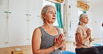 Elderly woman, meditation and yoga class with prayer hands for spiritual wellness, zen or inner peace. Senior group, people or yogi meditating in lotus pose for health, awareness or stress relief