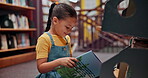 Reading book, story or girl in a library for a fantasy in school campus for education on bookshelf. Smile, learning or smart child student with scholarship studying knowledge, research or information