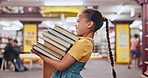 Books, education or child in a library walking with smile for knowledge or development for future learning. Scholarship, carrying or happy student at school studying information to search for a story