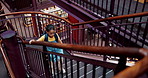 Girl, child and walking in library with books for research, education and knowledge for school project. Children, student and stairs on campus with bookshelf, learning and studying for scholarship