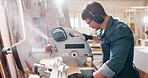 Machine, saw and man in workshop with wood project in carpentry and process of cutting plank. Woodworking, carpenter or handyman with tools for manufacturing and construction on table with equipment