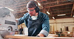 Saw, machine and man in workshop with wood project in carpentry and process of cutting plank. Woodworking, handyman and carpenter with tools for manufacturing and construction on table with equipment