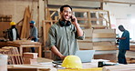 Phone call, carpenter and man in workshop with laptop for maintenance, remodeling and construction business. Manufacturing, furniture factory and person on smartphone for chat, talking and discussion