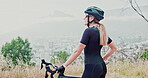 Woman, mountain bike and cliff view for exercise rest or training commitment, fitness or workout. Female person, helmet and cycling on hill for outdoor cardio with road challenge, sports or nature