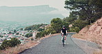 Woman, mountain and road with cyclist, challenge and exercise bike with endurance and training with sunshine. Person, view and cycling with wellness and nature with weekend break, sports and activity