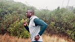 Man, running and mountain for exercise sports in raining weather for commitment, routine or discipline. Male person, earphone and fitness as healthy athlete for marathon cardio, training or outdoor