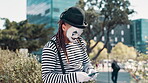 Mime, city and smartphone for funny text or online for communication for laughter, entertainment and joke. Male person, cellphone and street performer in Atlanta for comedy or character with makeup.