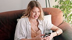 Phone, smile and woman on sofa at her home networking on social media, mobile app or internet. Happy, typing and female person scroll on cellphone with online website in living room at apartment.