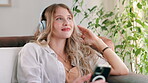 Lounge, headphones and woman with smile for music in phone, listening and relax on couch for peace. Technology, girl and female person in living room with mobile for streaming with internet in home