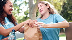 Happy people, volunteer and box with food for donations for charity, NGO or community service in nature. Group, team or society with smile for parcel, package or packing grocery bags at outdoor park