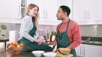 Man, woman and feed fruit in kitchen, morning and breakfast for nutrition and wellness with love. Couple, together and home for healthy diet with commitment and bonding with food, happiness and dance