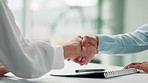 Signature, handshake and business people with deal, contract or agreement in office at desk. Shaking hands, closeup and consultant signing document for b2b partnership, acquisition or negotiation
