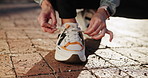 Hands, runner or person on ground to tie shoe lace for fitness training, walking exercise or workout. Running, closeup or athlete on floor in sports footwear ready to start outdoor hiking for travel