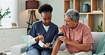 Senior man, sofa and nurse with blood pressure for heart rate, cardiovascular support and results. Elderly person, healthcare and machine in living room for hypertension, consultation or medical test