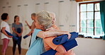 Yoga, women and friends hug at class for greeting, meeting and exercise together. Pilates, happy and senior people embrace at club for wellness, fitness and healthy body with mat at gym for care