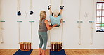 Stretching, women and rope on wall for yoga, exercise and senior person practice iyengar together in gym. Flexibility, body health or mature instructor help for wellness, wellbeing or fitness at club