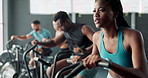 Fitness, gym or black woman on cycling machine for a biking workout or cardio training for endurance. Cyclist, exercise bike and healthy sports person on bicycle for energy, challenge or wellness