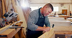 Man, carpenter and wood with drawing at workshop for furniture and design. Mature person, handyman and carpentry for repair on startup business as manager or supervisor with woodwork at warehouse
