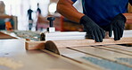 Hands, man and carpenter with cutting for wood at workshop for furniture and design. Closeup, carpentry and machine on startup business for manufacturing in warehouse, factory and handyman.
