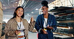 Warehouse, colleagues and women talking, smile and teamwork in construction site. Collaboration, fist pump and staff in uniform, inspection and employees of business, clipboard and manufacturing