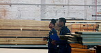 Warehouse, colleagues and black people, inspection and teamwork in construction site. Collaboration, man and woman in uniform, pointing and employees of business, clipboard and wood to check