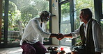 Senior man, handshake and meeting with relax for therapy, session or agreement on living room floor at home. Elderly male person or friends shaking hands for zen, aroma partnership together at house