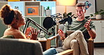 Happy man, interview and laughing with podcast in meeting for discussion, conversation or news at studio. Young people on air or talk show together with mic for communication, live chat or recording