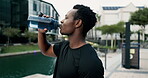 Man, drinking water and break outdoor with fitness for hydration, relax and morning exercise for healthy body. Athlete, black person and dehydrated with liquid bottle in city for wellness and workout