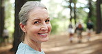 Mature, face or happy woman hiking in woods or nature for peace, trekking or outdoor adventure. Smile, relax or hiker walking in park, forest or Norway for exercise or wellness on holiday vacation