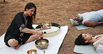 Tibetan, meditation and people with sound of singing bowl for indigenous spiritual healing in holistic practice. Soul, music and relax to calm vibration outdoor in nature with peace from instrument