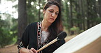 Woman, nature and shaman frame drum for spiritual healing, holistic and sound therapy in forest. Young healer or person with natural wellness in the woods and music or traditional performance outdoor