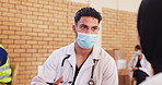 Doctor, man and consultation for healthcare with mask for help, conversation or volunteer at charity. Medical professional, talk and patient in clinic for check up, advice or communication of results