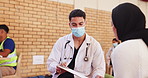 Doctor, woman and health outreach for community service with consultation, healthcare checklist or volunteer. NGO, charity and man in discussion for medical support or social responsibility with mask