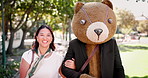 Walk, park and woman on date with teddy bear in costume for outdoor bonding, fun and mascot. Romance, smile and couple in nature with animal mask, laugh and happy in sunshine, trees and outdoor love