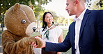 Businessman, mascot and happy with handshake in outdoor to introduce or deal and agree for negotiation and promotion. People, cartoon character and costume for entertainment with fun and smile