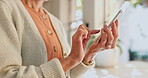 Senior woman, phone and hands for conversation in home, reading notification and scroll on blog. Elderly female person, typing and text for communication, closeup and social media for streaming