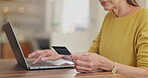 Senior woman, credit card and laptop for payment in home, ecommerce and internet banking for transaction. Elderly female person, finance and typing account number on website, online and investment