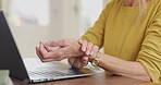Mature woman, laptop and wrist pain with arthritis, osteoarthritis and joint inflammation with closeup. Senior person, healthcare and hand massage for tension relief, medical problem and muscle ache