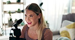 Woman, microphone and podcast with phone, talk and live stream for audience on internet in home living room. Girl, presenter and influencer with smile for vlog, discussion and ideas on social network