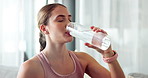 Woman, drink water and hydration after home fitness, workout in living room with liquid for health and wellness. Exercise, training and thirsty athlete with pilates or yoga, power and challenge