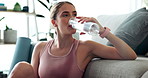 Woman, drinking water and hydration after home fitness, workout in living room with liquid for health and wellness. Exercise, training and thirsty athlete with pilates or yoga, power and challenge