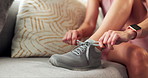 Hands, shoelace and woman in home for fitness, running and health with shoes on sofa in living room. Person, prepare and ready with sneakers on couch for training, exercise or workout in apartment