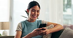 Home, woman and cellphone with typing, smile and online games with digital app and message a contact. Apartment, person on a couch and girl with a smartphone and mobile user with a blog and email