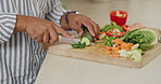 Hands, knife and vegetables for cooking in kitchen with meal prep for nutrition, wellness and vegan diet in home. Person, chef and ready for food with cucumber for salad, lunch or dinner in house