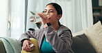 Living room, woman and drinking water in bottle for fitness, natural nutrition or break in exercise. Athlete, hydration and organic liquid on sofa for healthy diet, detox and workout training at home