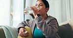 Relax, smile and woman drinking water on sofa in living room for hydration at apartment. Happy, rest and Asian female person enjoying health, fresh and wellness aqua beverage for nutrition at home.