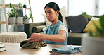 Cleaning, laundry and folding clothes with woman in living room of home for housework or chores. Clothing, housekeeping and washing with confident young person in apartment for household hygiene