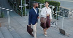 Business man, woman and talking in street on commute to work in metro with discussion, chat and walking. People, staff and employees with bag, outdoor and conversation for travel on metro sidewalk