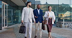 Business people, group and conversation in city on walk for commute to workplace with questions by buildings. Men, woman and employees with bag, outdoor and discussion for travel on metro sidewalk